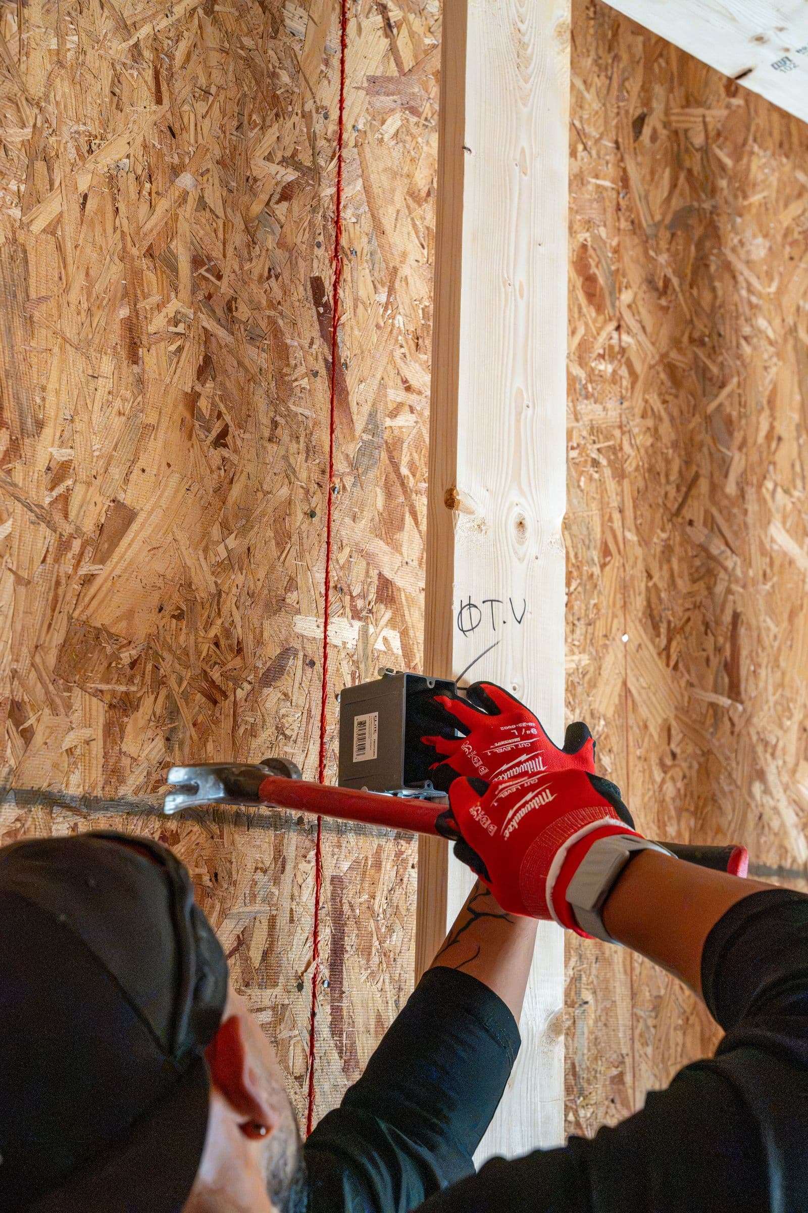 Gloved hands setting a box on a red laser line on a stud