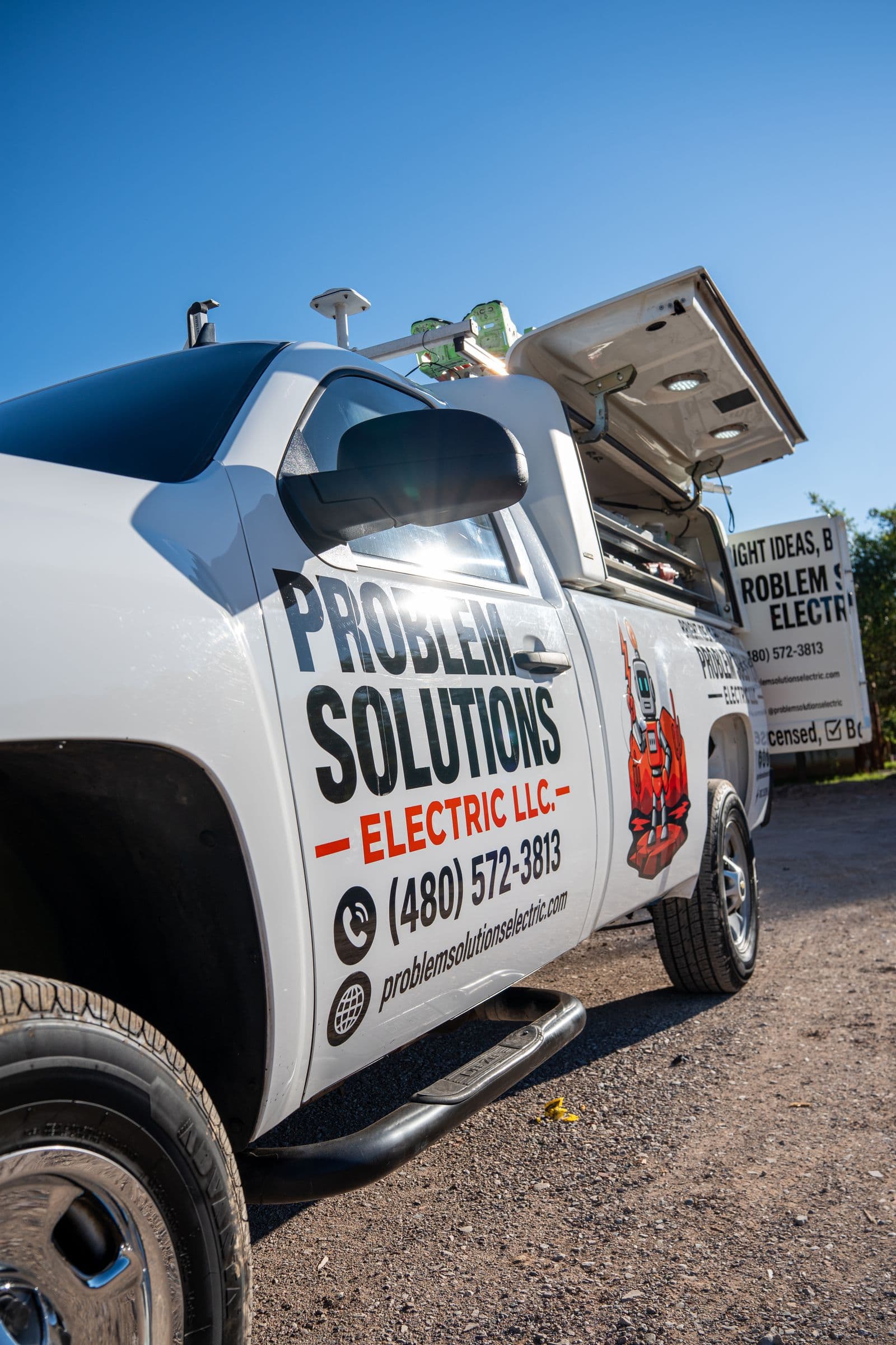 A company work truck with the logo, the robot and the phone number on the door
